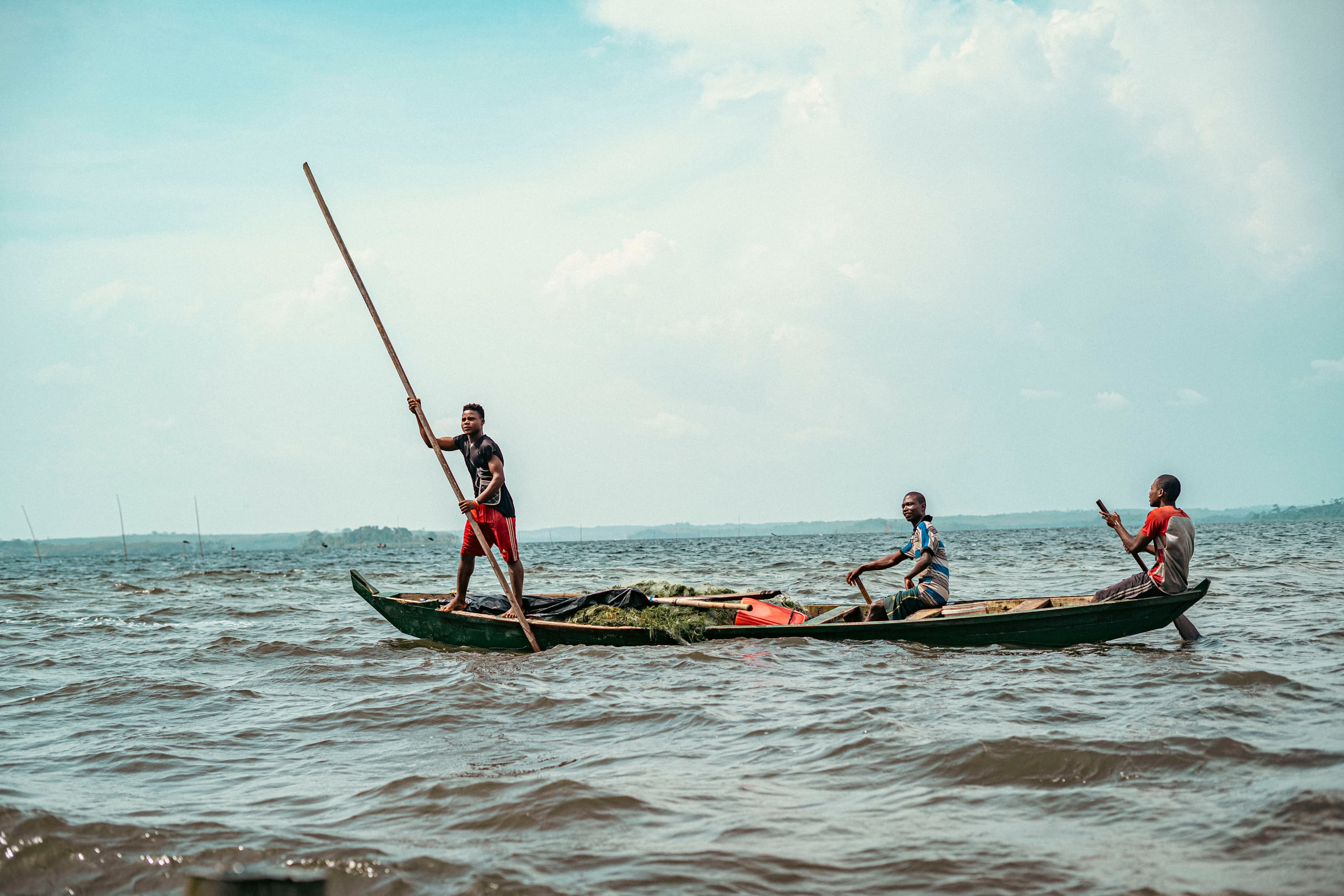 Fishermen navigating a traditional wooden boat across Lake Victoria, Nam Lolwe